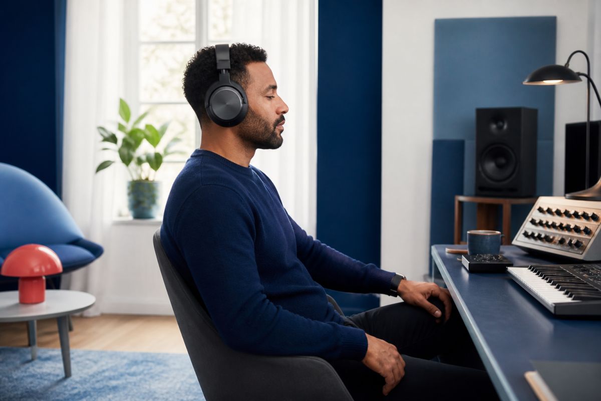 Music producer listening with over-ear headphones in a home studio